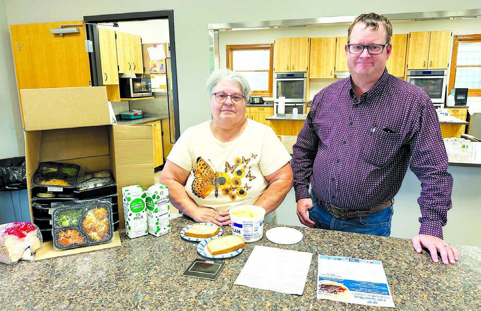 Ethel Hill and Rusty Gebhardt show the contents of a delivery box of 10 meals available once a month for senior citizens in the Timber Lake area residents.