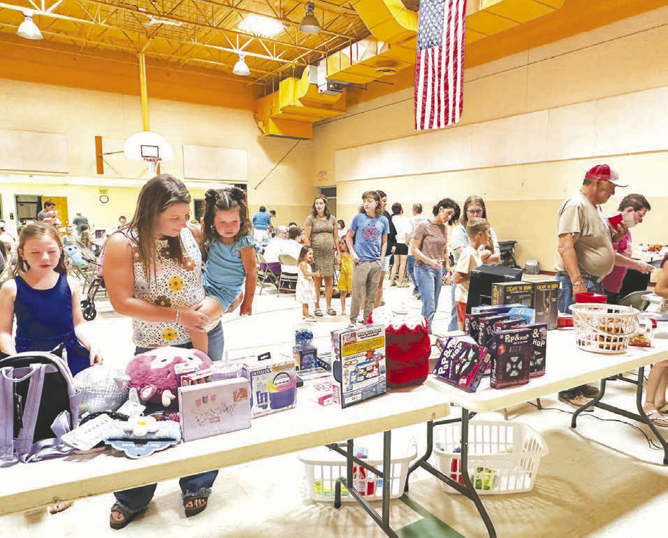 The Timber Lake Lakota Organization drew a large crowd for Bingo, prizes, and a meal on Sunday, August 23. At left, Kathryn Dupris helps daughter Aria choose a prize.