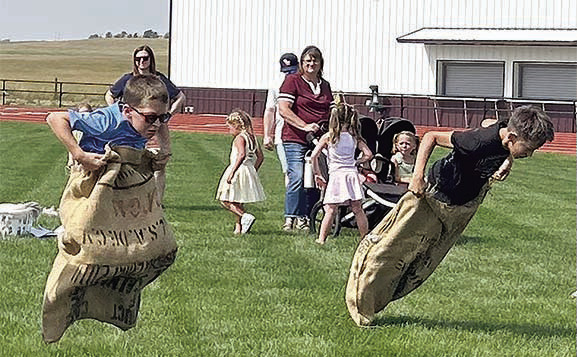 Lincoln Aberle (left) and Gunner O’Leary (right) racing to the finish in the potato sack race. Photo By Ann Arnold