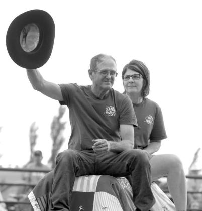 John and Patty Linderman, owners of Country Market in Timber Lake, were honorees at the Days of 1910 Rodeo on Saturday evening and circled the arena on a horse-drawn wagon to the acknowledgement of the crowd. John is waving the hat that belonged to the late Glen Cudmore, longtime rodeo volunteer. Photos by Jon Flatland