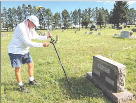 Benton Smith of Sentry Mapping Services in Oxford, MS, logs in GPS coordinates and photographs a headstone as part of a mapping project at the Timber Lake Cemetery. Photo by Jon Flatland