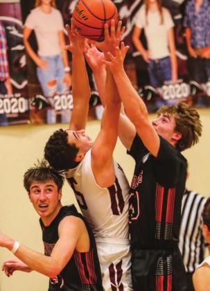Timber Lake senior Trenton Hansen fights for a rebound between Faith’s Tyson Selby (L) and Joel Gifford.