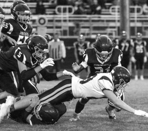 Timber Lake’s Caleb Quinn (21) jumps on a Newell ball carrier as Hank Kraft wraps up his legs with Trenton Hansen (5) and AJ Lindskov (55) moving in.