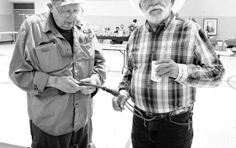Sea of Grass artists James Pollock (left) of Pierre and Mick Harrison of Belle Fourche check out some leather work by Don and Unalee Howe of Dupree (pictured below). Unalee was director of the Sea of Grass art project in 2015.