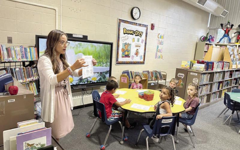 Timber Lake School librarian LeAnn Thompson was ready for students on the first day of school on Monday, Aug. 18. Here she tells Kindergarteners that they can check out books to take home and introduces them to the rules on how to care for books. Photo by Kathy Nelson