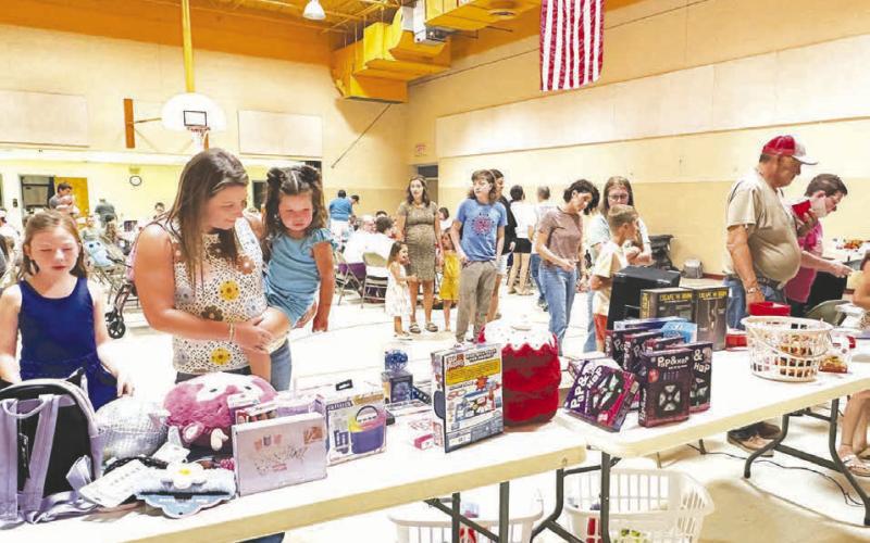 The Timber Lake Lakota Organization drew a large crowd for Bingo, prizes, and a meal on Sunday, August 23. At left, Kathryn Dupris helps daughter Aria choose a prize.