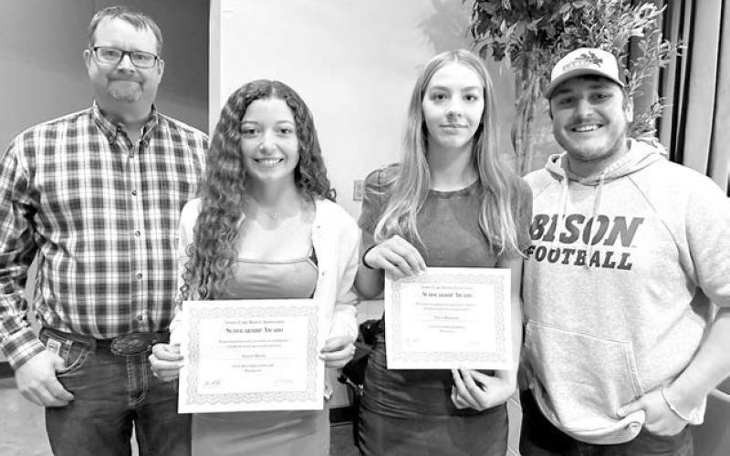 Rusty Gebhardt (left) and Shaun Maher (right)of the Timber Lake Rodeo Assn. awarded $1,000 scholarships to Arianna Bieber (left) and Gailup Bollinger (right). Both girls have been dedicated volunteers at the Rodeo Association’s Days of 1910 Celebration.