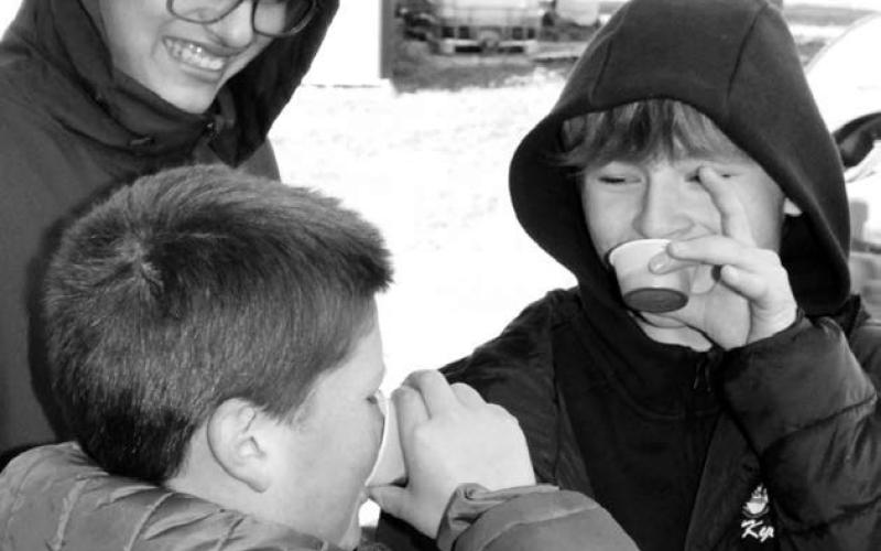 Dupree seventh graders Dean Longbrake and Kyle Lawrence samples the fresh buffalo blood while their classmate Lawrence Young observes them.