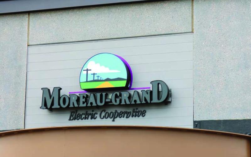 An electrical technician works atop the roof of the new Moreau-Grand Electric Cooperative building last week while wiring the sign above the main entrance. The sign looks most impressive when lit at night. Photo by Jon Flatland