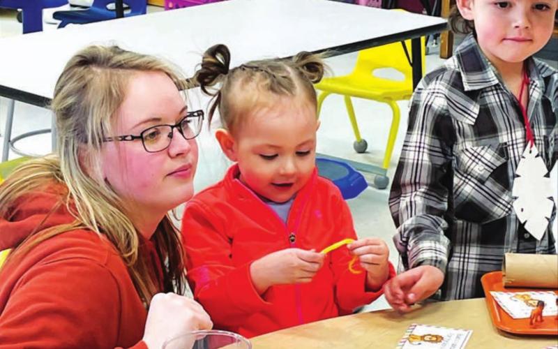 Shayna Traversie helps children Rylie and Jayden with a jungle animal project.