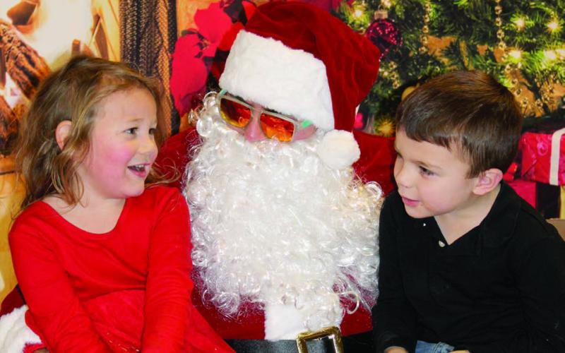Olive Anderson and Kaysen Smith eagerly shared their Christmas wish lists with Santa Claus during his visit to Dupree for the community’s annual Parade of Lights celebration on Dec. 6. Topic photo by Patty Peacock