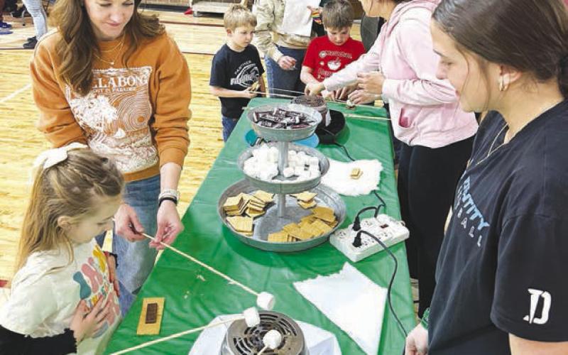 Lakyn Lindskov and her mom, Marisa, make ‘smores, a camping treat.
