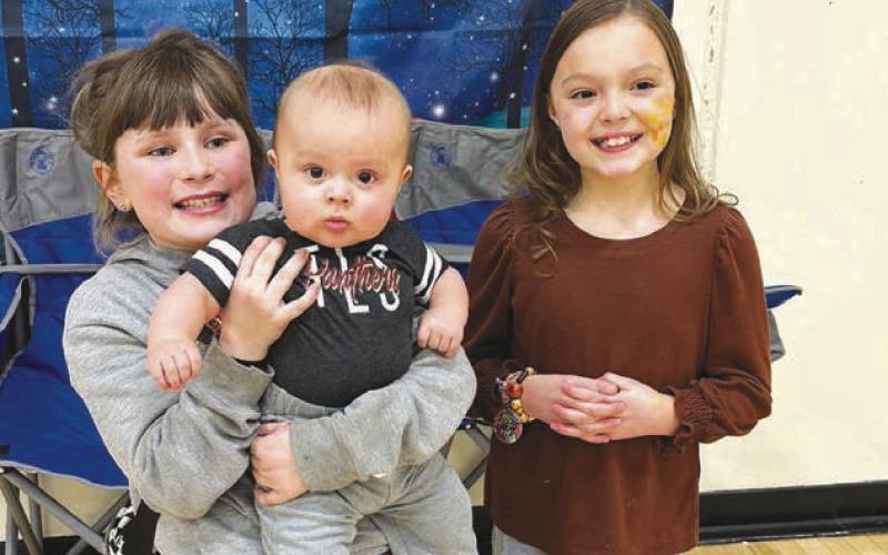 Clara Nilson (left) and Zoey Spiel wtih Zoey’s little brother, Bud, at the photo booth