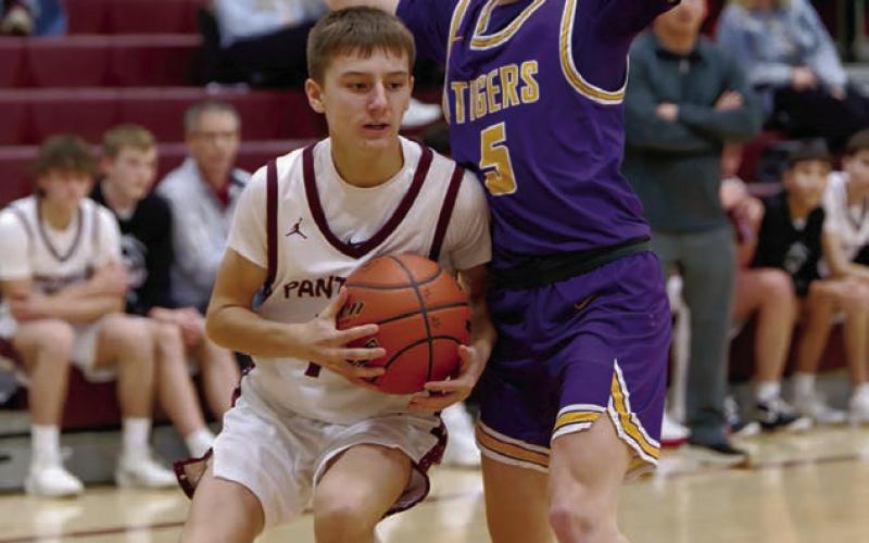 Panther guard Kruz Lindskov gets bumped by a New Underwood defender as he works his way along the baseline . Find more boys and girls basketball coverage on Pages 8 and 9. Topic Photo/Marie DuPreez