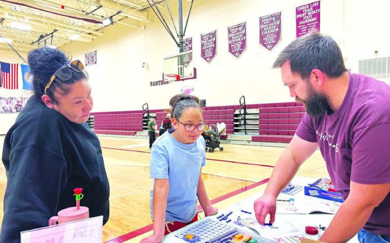 Sophia Ley and her aunt, Colette Brown Otter, visit Walker Rose’s table to see what they can learn.