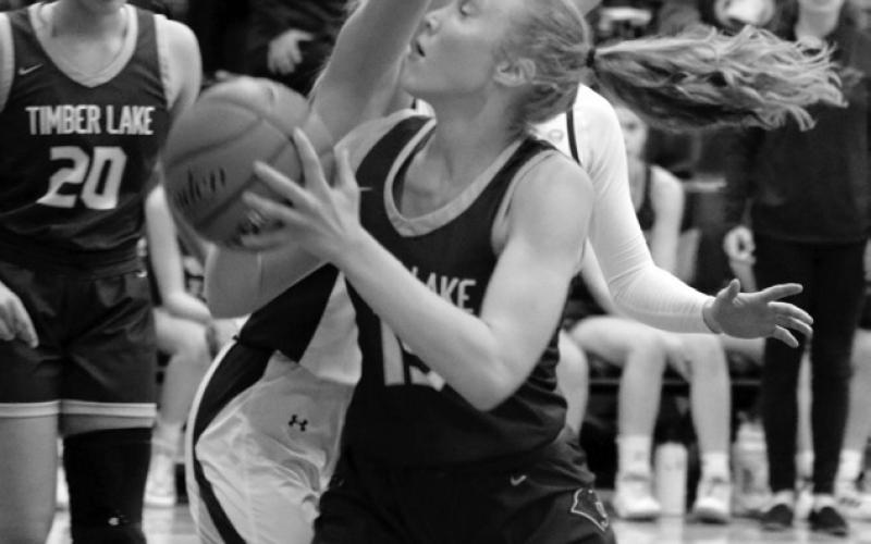 Junior forward Kendyl Locken is fouled by a Castlewood player on a move to the hoop during Timber Lake’s battle with Castlewood in the SoDak 16 Tournament last Thursday, March 2. Looking on is Jasmine Nash (20). Photo by Jon Flatland