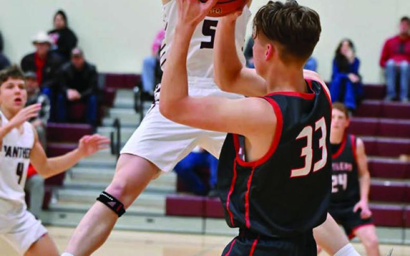 Timber Lake junior forward Holden Gill (5) leaps while attempting to block an outlet pass by Potter County’s Jonah Pribyl (33) last Friday, Feb. 28. The Panthers won a nail-biter and are playing in the Region 8B Tournament this week. Photo by Marie DuPreez