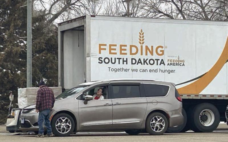 A Feeding South Dakota volunteer interacts with a food recipient at the organization’s March food distribution on Main Street of Isabel. Photo by Jon Flatland