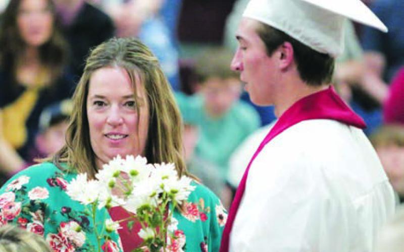 Exchange student Francesco Barbini from Italy presents flowers to his host parent, Leah Peterson.