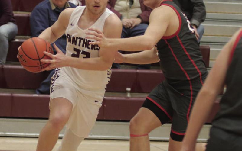 Timber Lake senior Brady Sandquist makes a move past Potter County defender Alex Tanner during the Panthers’ 70-49 win over the Battlers in the regular season finale last Friday, Feb. 24.