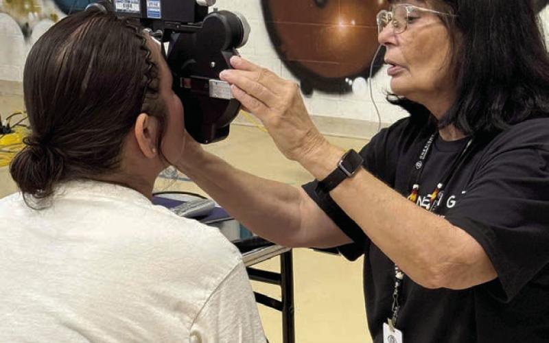 A volunteer optometrist gives an eye exam during a free vision clinic held in Eagle Butte last week. A total of 987 people were served. The event was sponsored by the Cheyenne River Youth Project. Photo by CRYP