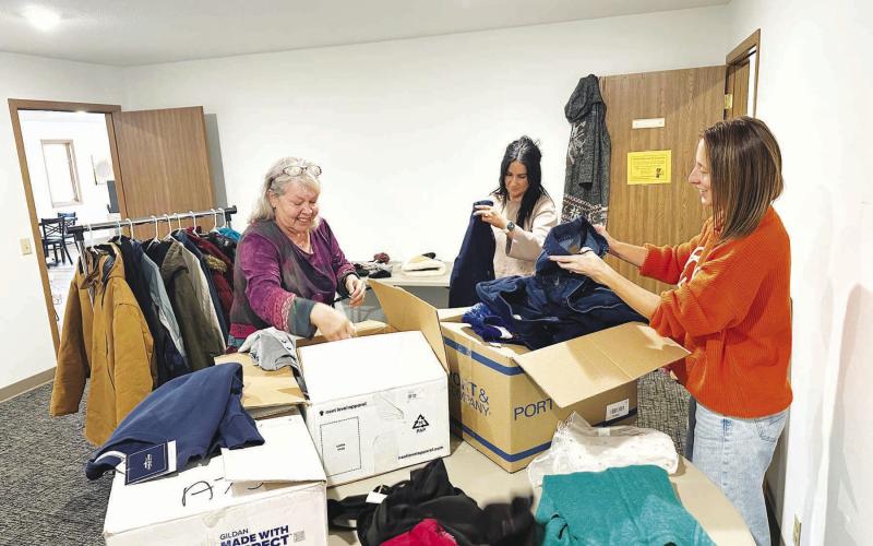 A community drive to make winter coats, jackets, gloves, boots, and other cold-weather clothing available to those who need it got off to a start last week. Here (l-r) Lilian Turcotte, Becky Booth and Kasey Maher sort donations to be displayed. Anyone is welcome to take what they need or drop off new or gently used items of all sizes at The Junction. The room behind the Grounded Coffee Shop will be open Tuesdays through Fridays from 9 a.m. to 4 p.m. until further notice. Photo by Kathy Nelson