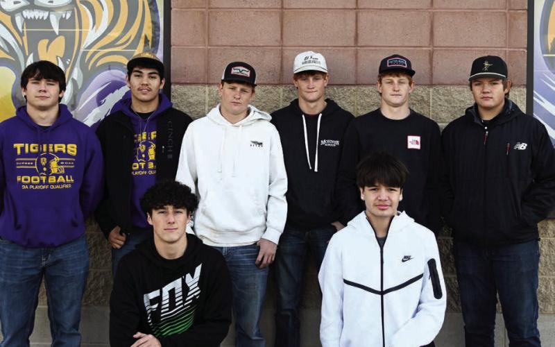 The 2025 Little Moreau Conference champion Dupree Tigers, above, had eight players selected to receive all-conference football honors. Pictured are front row (l-r) Traden Meeks and Ricco Swallow, both honorable mention selections, and in the back row (l-r) are all-conference honorees Michael Donovan, Braxton Schad, Tee Birkeland, Cruz Birkeland, Fletcher Birkeland and Tanner Thorstenson. Above right, seniors Tayshaun Cudmore and Spencer Olsen (l-r) were Class A Cross Country All-State selections for posting