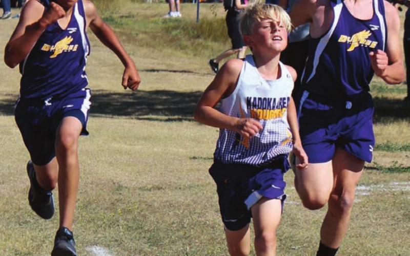 ABOVE LEFT: Dupree’s Tripp Schrempp (L) and Case DePoy converge on either side of a Kadoka runner as they approach the finish line in cross country action at the LMC meet Saturday. Photo by Patty Peacock