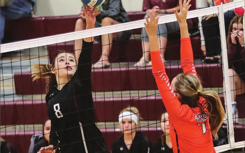 Photo by Robert Slocum Kenna Webb tips the ball over the outstretched arms of Mobridge-Pollock’s Regan Stoick during their game on Sept. 17 in Timber Lake.