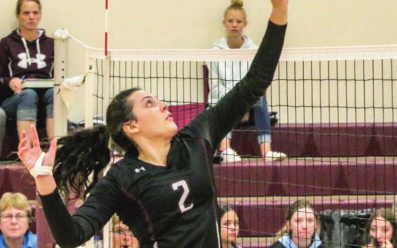 Senior Maci Maher rises up to reach a ball during the LMC tournament.