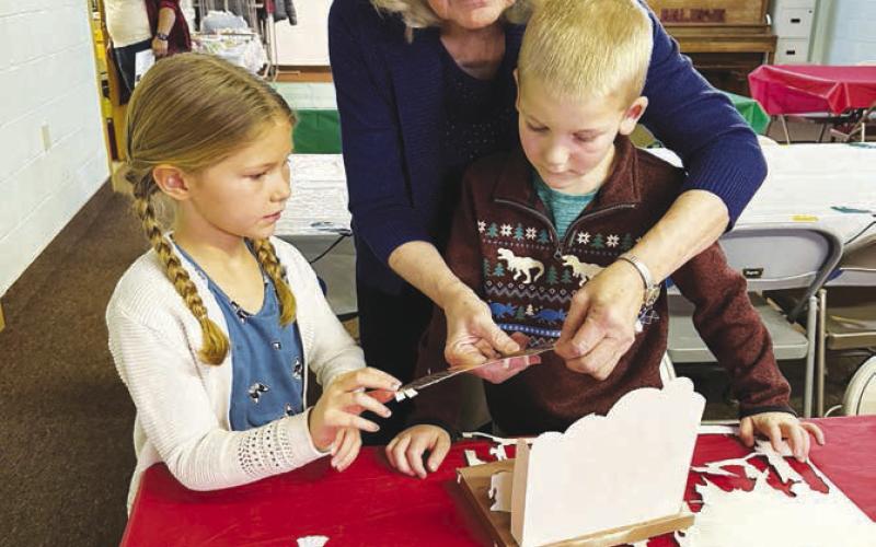 Laurel Reinbold helps Tessa O’Leary and Andrew Zeug construct a nativity scene at United Parish.