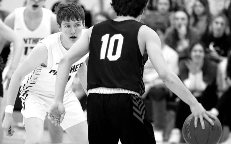 Timber Lake forward Curtis Connor (above) is fouled as he drives the lane during nonconference boys basketball action against Mobridge-Pollock on Monday, Feb. 20. At left, junior Tell Murray is focused on defending Tiger guard Simon Fried as he brings the ball up-court. The Panthers snuck out a 52-48 win over Mobridge-Pollock to improve to 10-9 overall while the Tigers dropped to 10-10 on the season. Photos by Jon Flatland