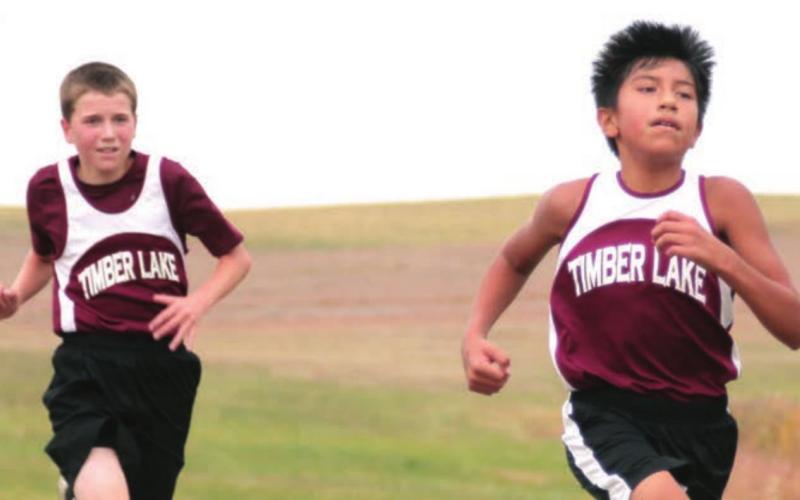 Demetrius Sanchez and Thomas Holzer race in their home cross country meet.