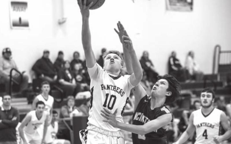 Timber Lake’s Gracen Hansen tries to finish a fast break as McIntosh’s Ty Nehl plays defense during their Region 8B contest in TL. Photo by Robert Slocum