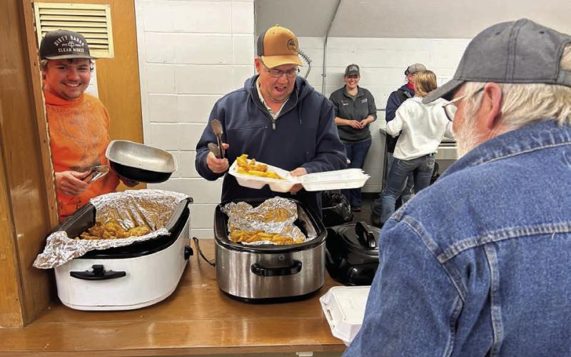 Tye Boldt (left) and Tucker Stocklin share a laugh while dishing up fish and French fries forTim Johnson at the annual Knights of Columbus fish fry at the Isabel Community Center last Friday, March 28.The K of C fish fry moves to Trail City this Friday, April 4, and will be held in Timber Lake on Friday, April 11. (See advertisement on Page 11) Photo by Jon Flatland