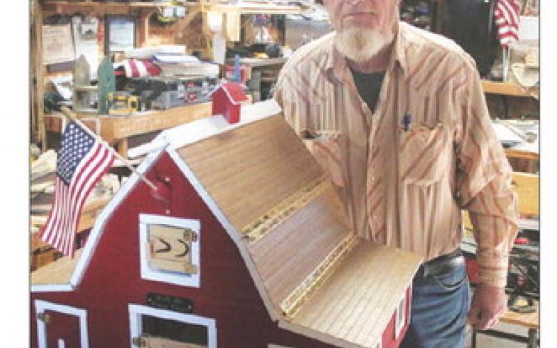 Dave Doan with one of his handcrafted barns. Photo by Jon Flatland
