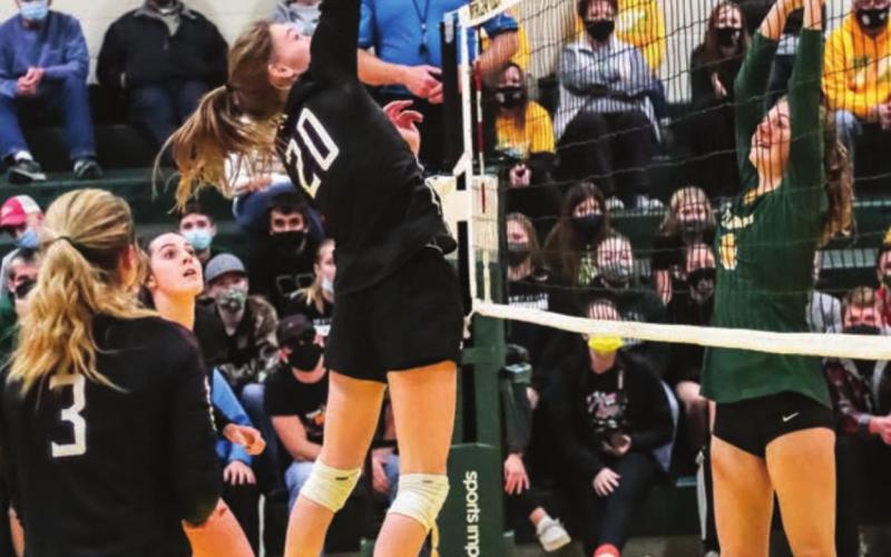 Molly Kraft skies up high to tip the ball over the net.