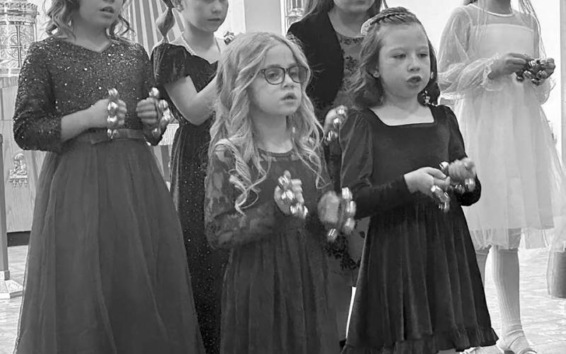 The K4J Choir from Holy Cross Church sang “Come and Rejoice” and “Silent Night,” accompanied by Cheryl Lawrence. FRONT: Elsie Maher, Bexley Dupris; BACK: Brie Parker, Tessa O’Leary, Molly Dupris, and Rose Maher.