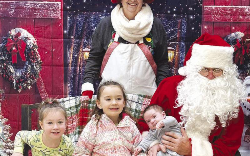 RIGHT: The Bollinger girls, Payton and Faith, brought their new baby brother, Tobias, to see Santa.