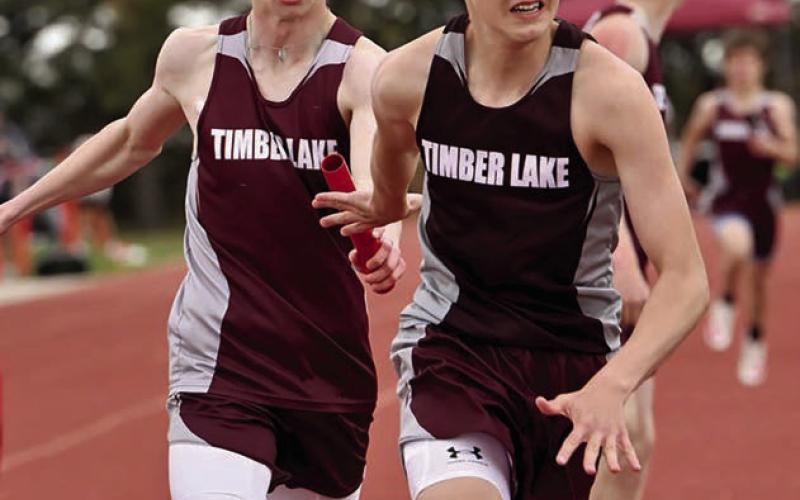 Timber Lake’s Holden Gill (left) passes the baton to teammate Landen Bieber during a relay race at the Timber Lake Track Invitational last Thursday, May 1, at Doug Kraft Field. Photo by Marie DuPreez