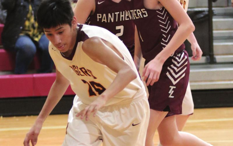 Panthers Cole Ducheneaux (L) and Kyler Bollinger (R) watch McIntosh’s Ashton High Cat chase a loose ball during their recent high school basketball contest. Photo by Jon Flatland
