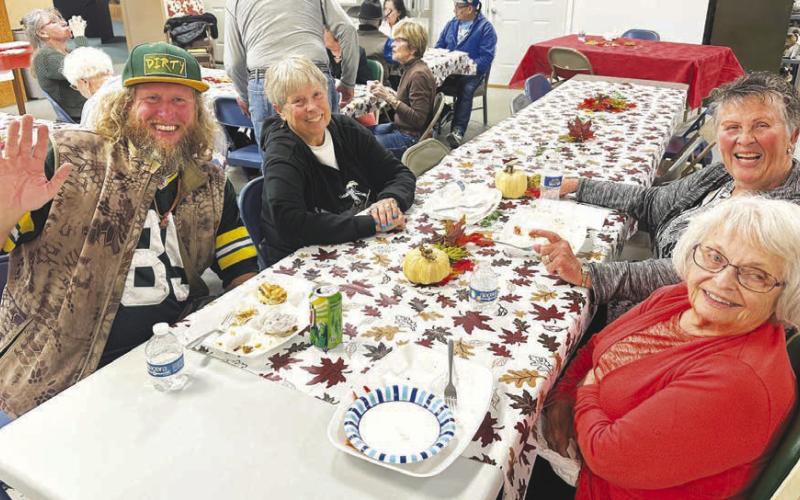 Nick Johnson (left) with a table of new-found friends at the Timber Lake Museum potluck dinner on Sunday (l-r) Johny Weber, Judy Garon and Patty Kjellsen.