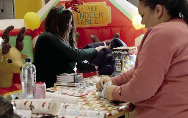 Volunteers wrap Christmas gifts for children at the Cheyenne River Youth Project in Eagle Butte.