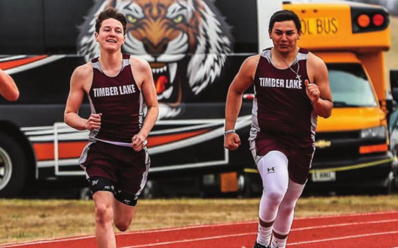 Timber Lake runners (L-R) Aidan Rough Surface, Tell Murray, Jaiden Ducheneaux and Ashton Kerstiens sprint toward the finish line in the 400m run. Photo by Robert Slocum