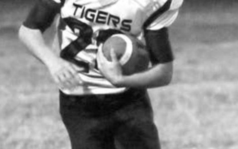 LEFT: JW Pederson runs with the ball for the Tigers. Photos by Jon Flatland