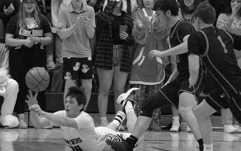 Timber Lake junior forward Rance Martin (34, on floor) pushes a pass to a teammate as he falls to the court after being tripped while playing low point in the Panthers quarterfinal win over Faith last Tuesday, March 4.