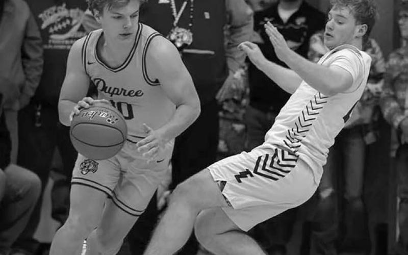 Dupree’s Braydon Terveen-Smith dribbles past Timber Lake senior Treyton DuPreez after they collided during a nail-biting Region 8B boys basiketball semifinal last Friday, March 7. DuPreez was whistled for a blocking foul on the play.