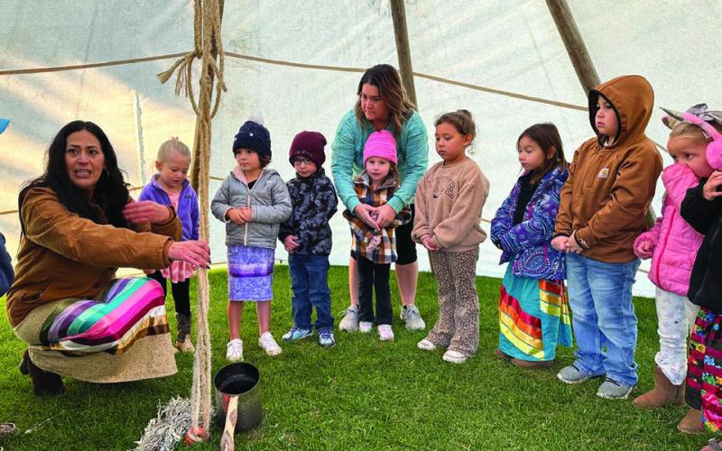 Michele West of Eagle Butte talks to the Timber Lake Pre-K class about how women made a family home in the tipi. Pictured (l-r) are Isabella Yuker, Jensyn Booth, Rowan Bridges, Scarlette Shepard with teacher Cara Lei, Lennox Bad Warrior, Ava Hettick, Katai Bartlett, and Drew Long.