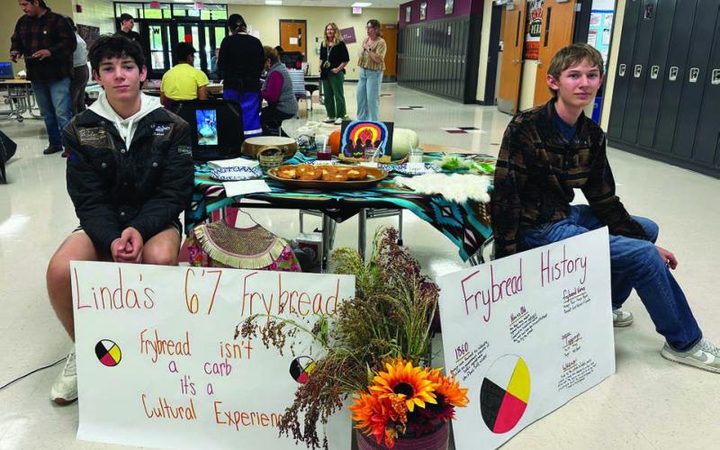 Linda Reinbold’s team won the Fry Bread Contest. Pictured with their display are two members of the team, Pete Maher and Gavin White. Students made and served the fry bread, shared their recipe, and included cultural components. A group of judges scored the entries.