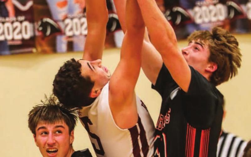 Timber Lake senior Trenton Hansen fights for a rebound between Faith’s Tyson Selby (L) and Joel Gifford.